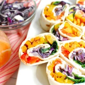 A rainbow roasted vegetable pinwheel propped up on a platter.