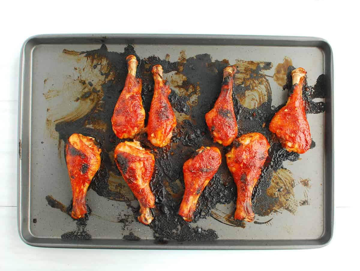 Chicken drumsticks on a baking sheet.