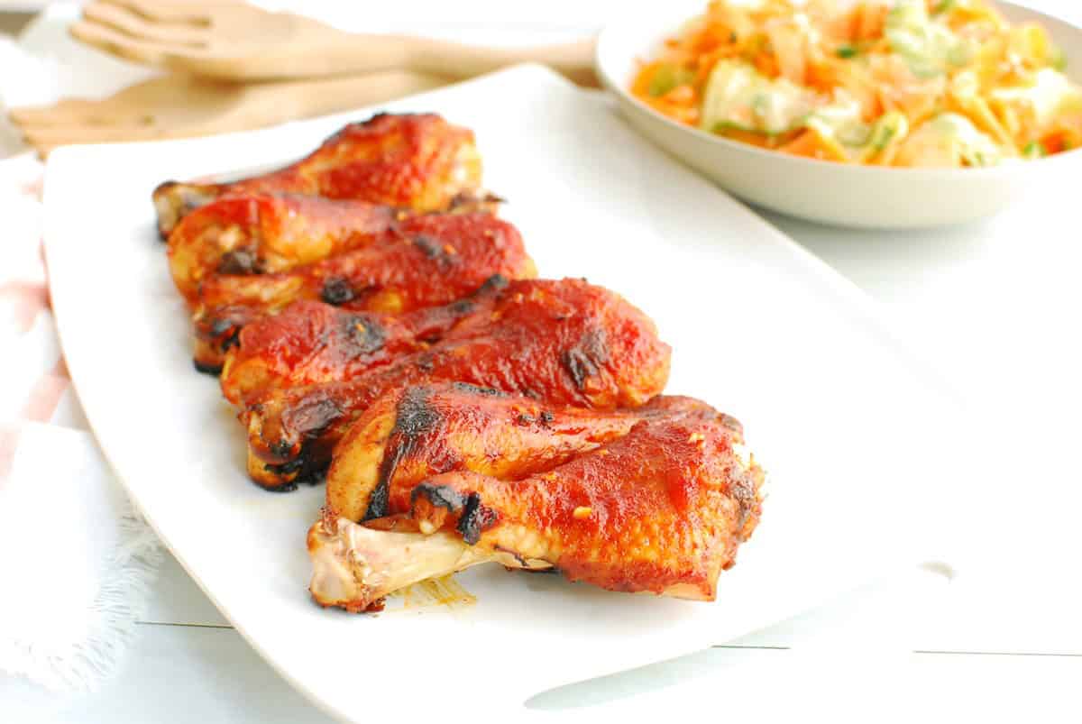 Several gochujang chicken drumsticks on a platter.