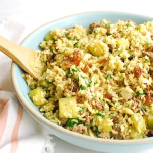 A large bowl filled with spiced lamb, zucchini, and rice.