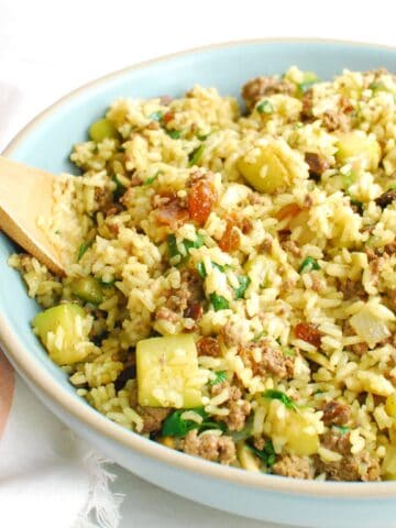 A large bowl filled with spiced lamb, zucchini, and rice.