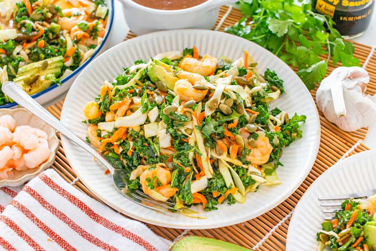 A miso kale shrimp salad on a white plate.