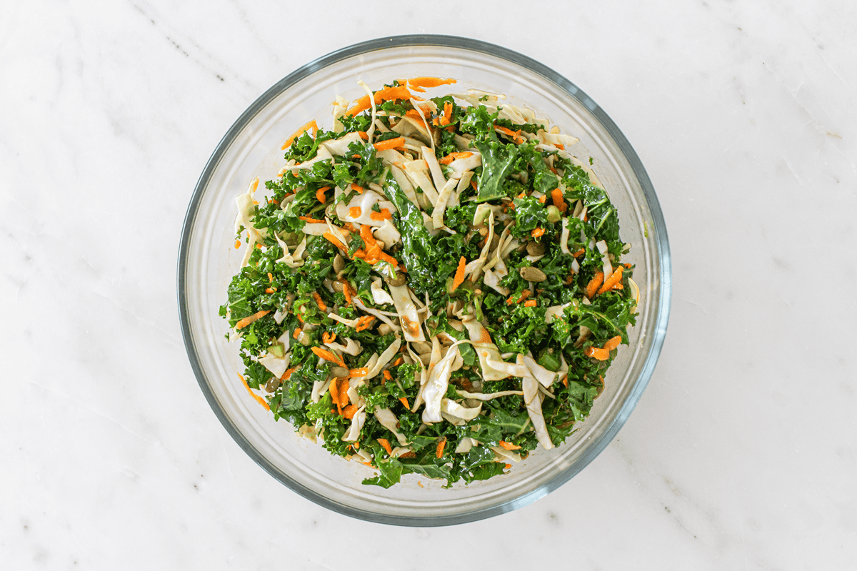 All the vegetables and pepitas mixed together in a large bowl with half the dressing.