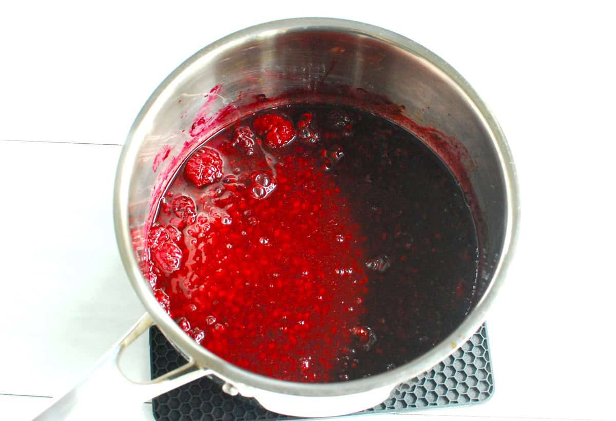 Mashed blackberries and lemon juice in a pot.