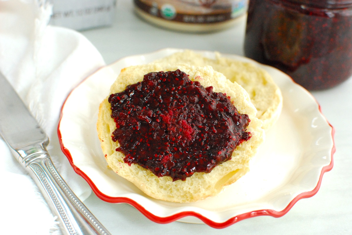 An English Muffin topped with blackberry chia jam.