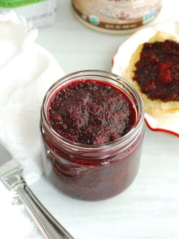 A jar of blackberry chia jam filled to the top.
