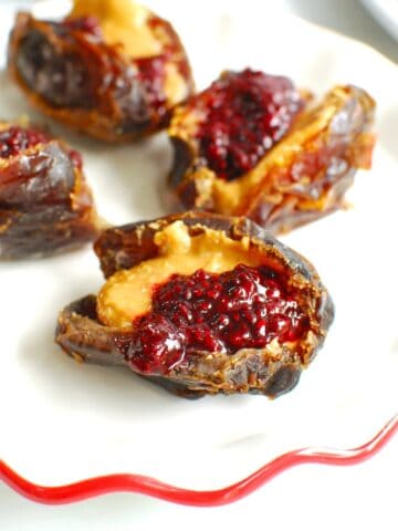 Peanut butter and jelly stuffed dates on a small plate.