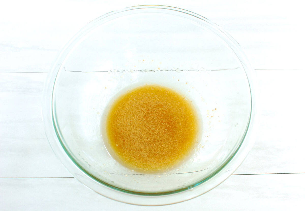 All the dressing ingredients mixed together in a glass bowl.