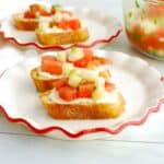 Two watermelon cucumber feta crostini on a plate.