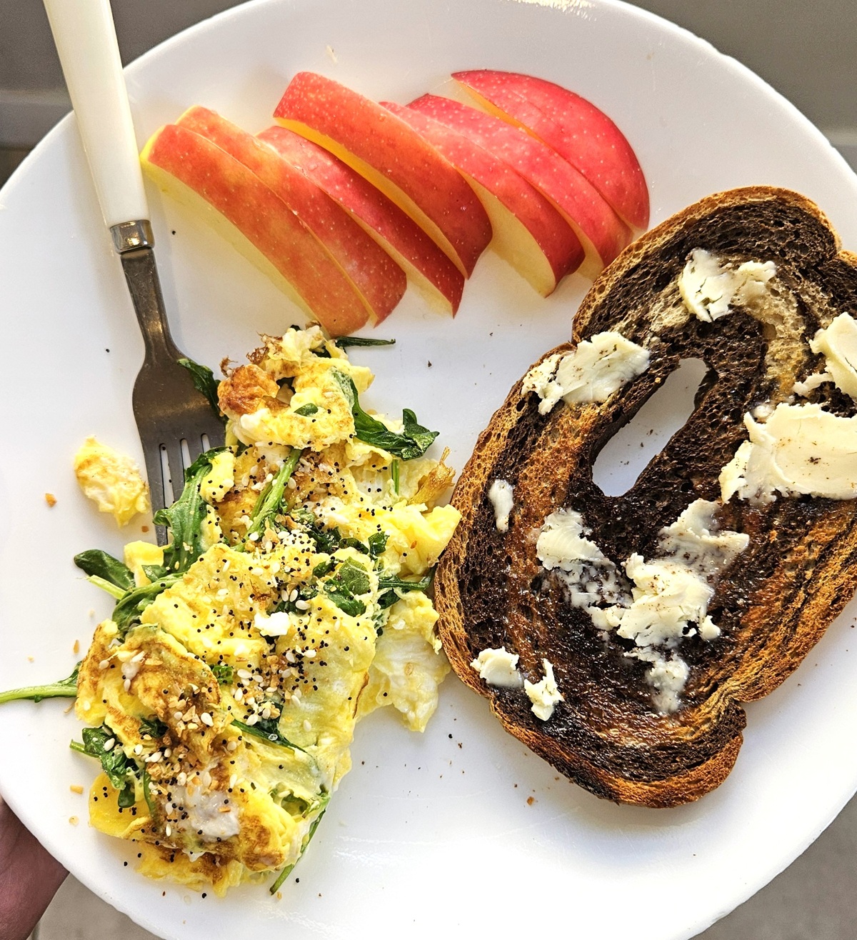 Eggs, toast, and sliced apple on a plate.