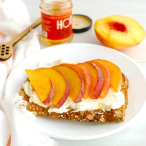 A slice of peach ricotta toast on a plate.
