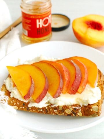 A slice of peach ricotta toast on a plate.