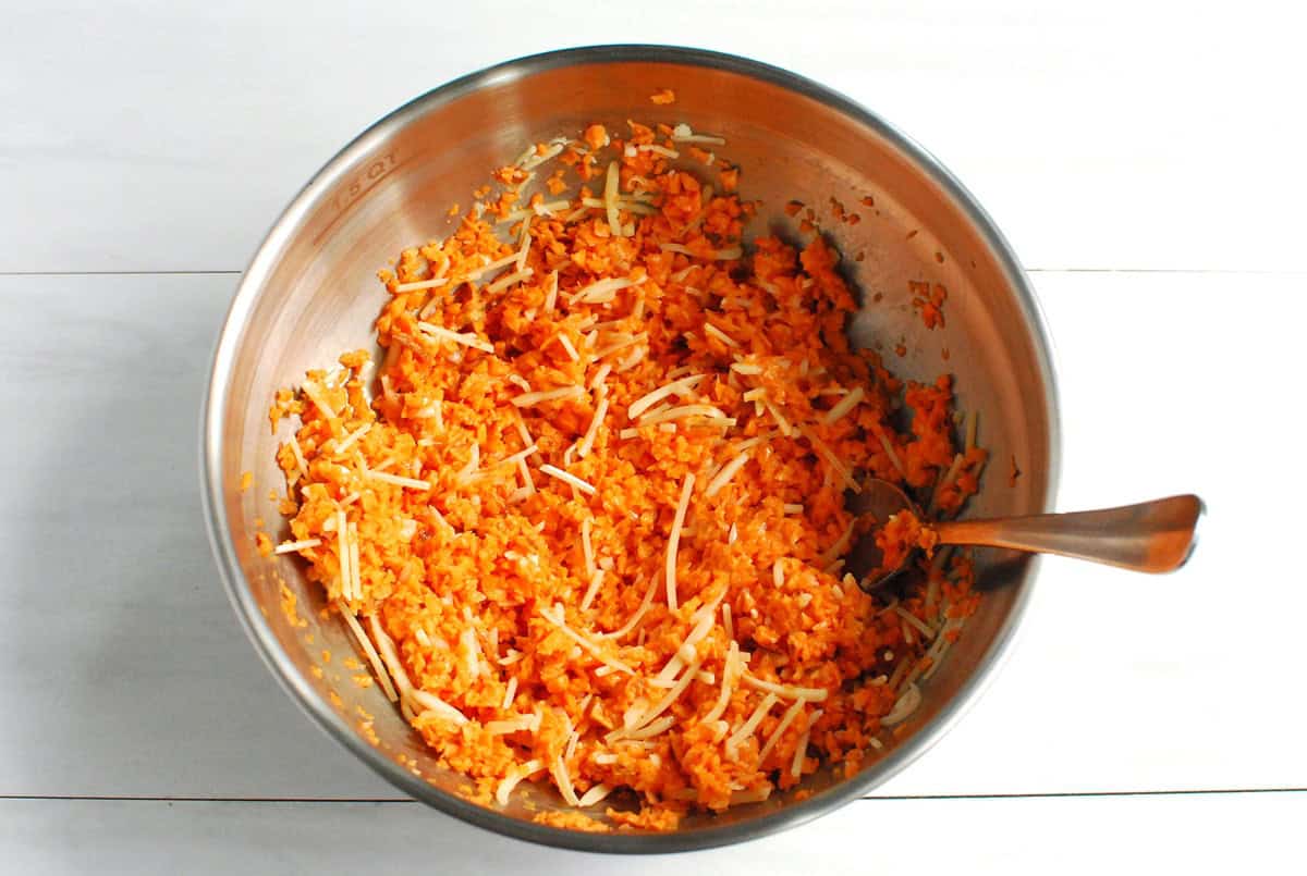 The finely chopped sweetpotato mixed with egg and cheese in a bowl.