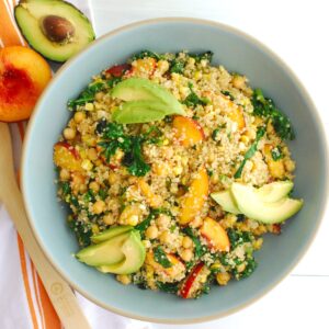 Overhead shot of a peach quinoa salad in a large blue bowl.
