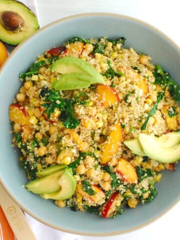 Overhead shot of a peach quinoa salad in a large blue bowl.