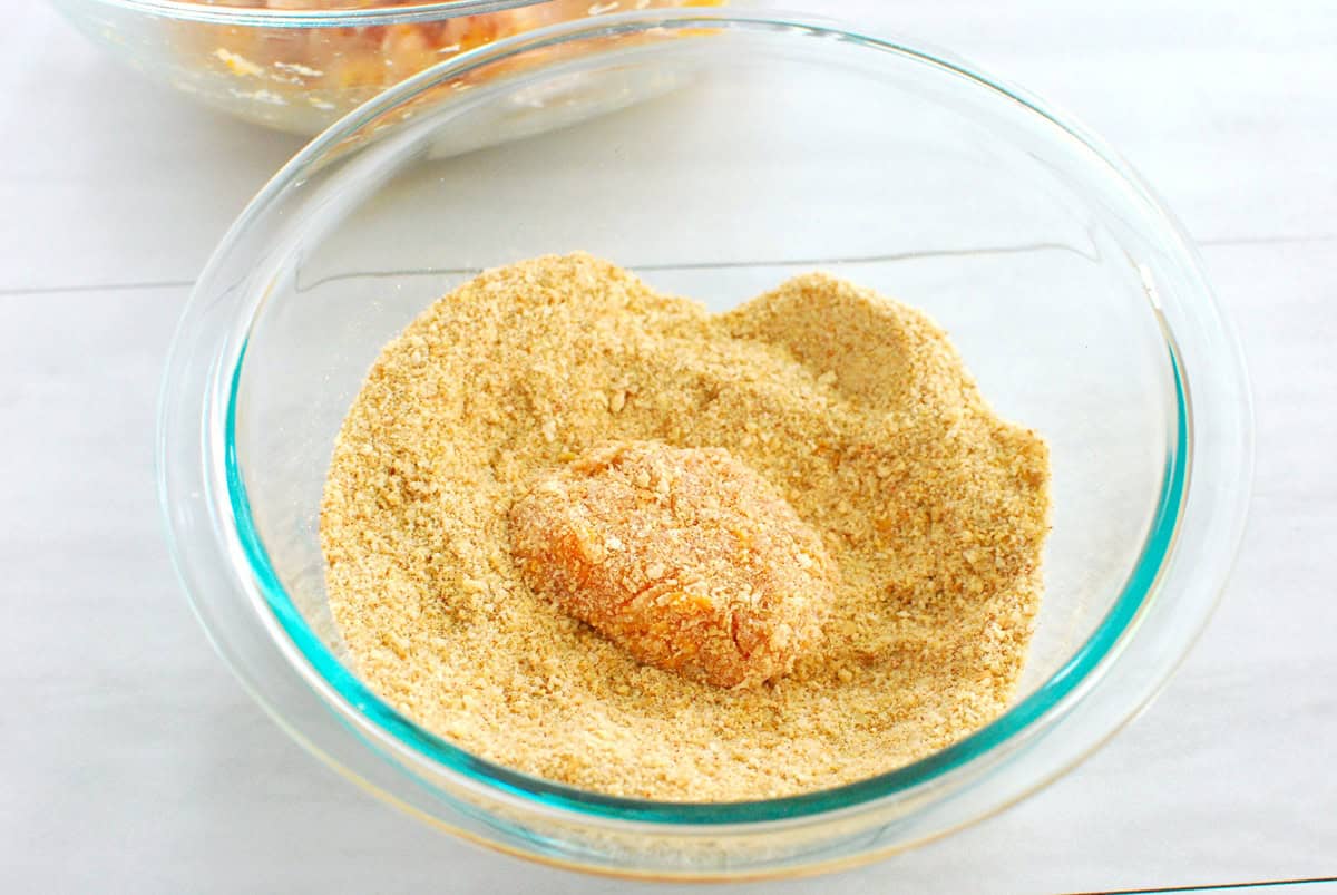 The ground chicken mixture shaped into a nugget and dipped into breadcrumbs.