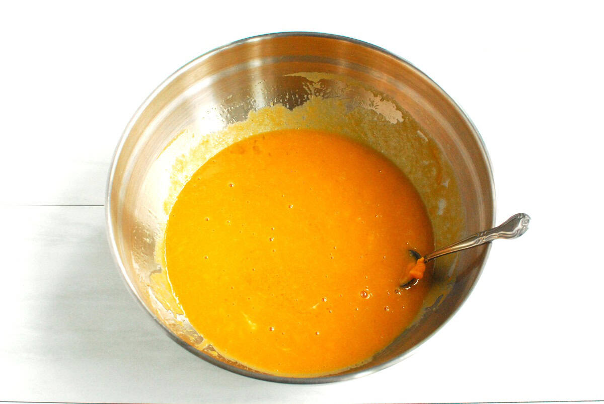 The sweetpotato puree, olive oil, maple syrup, almond milk, eggs, and vanilla extract mixed together in a silver bowl.