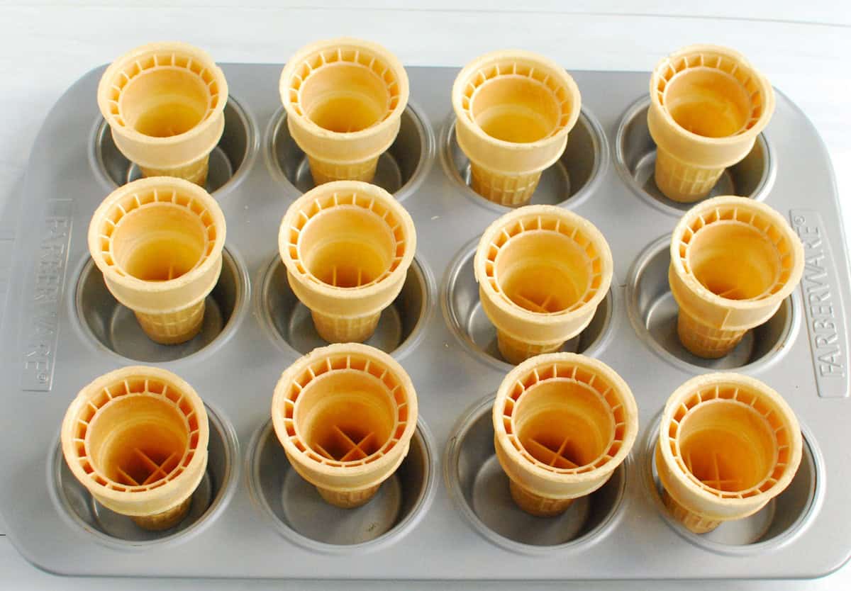 Ice cream cones placed into a muffin tin.