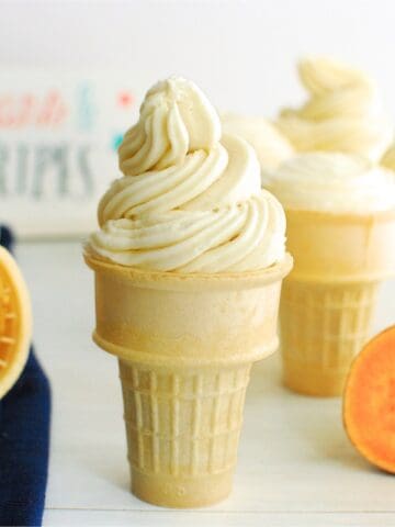 A sweetpotato ice cream cone cupcake with swirled frosting on top.