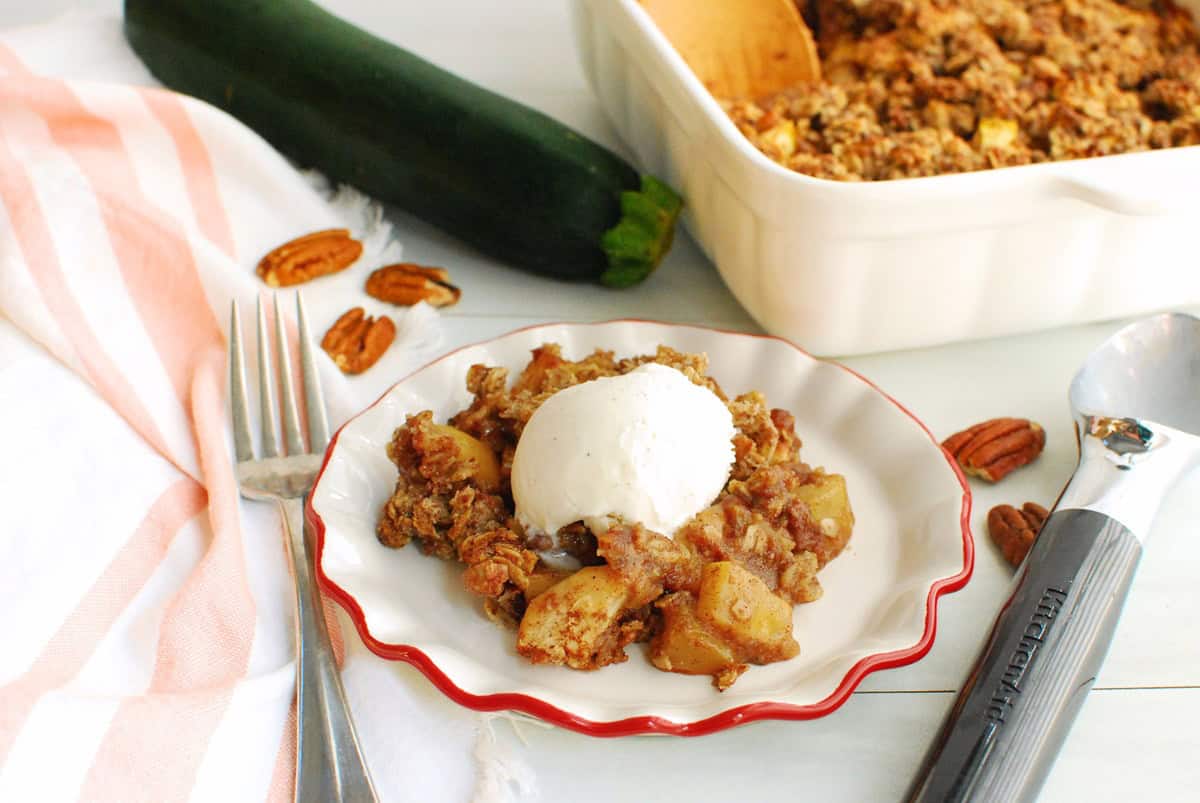 Zucchini crisp topped with ice cream on a small plate.