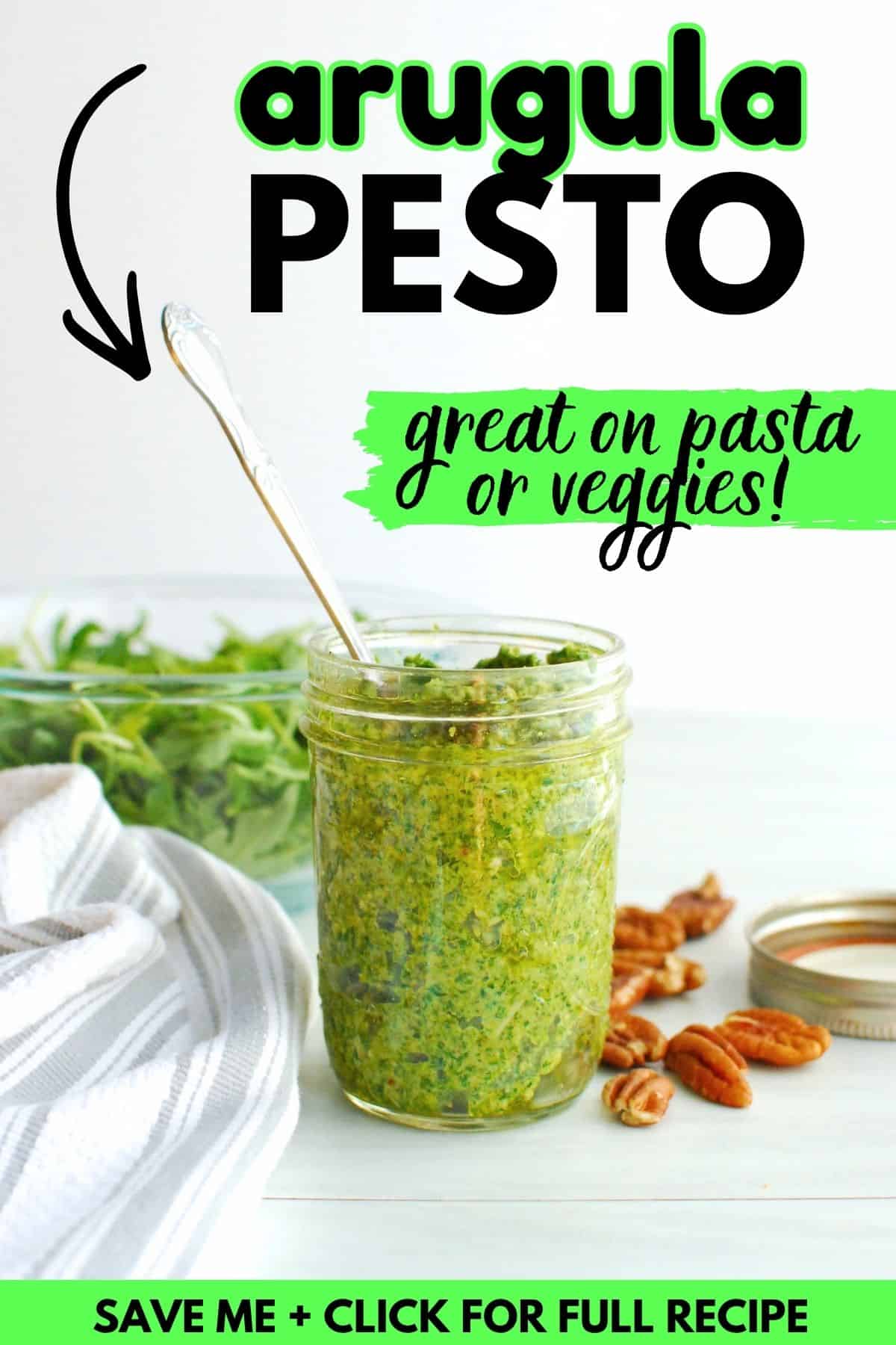 A jar of arugula pesto with a spoon in it, with a text overlay with the name of the recipe.