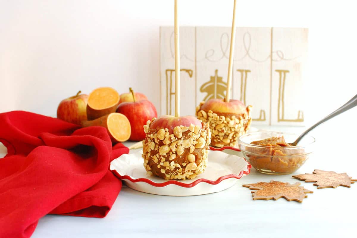 A caramel apple made with a sweetpotato date coating with chopped peanuts.