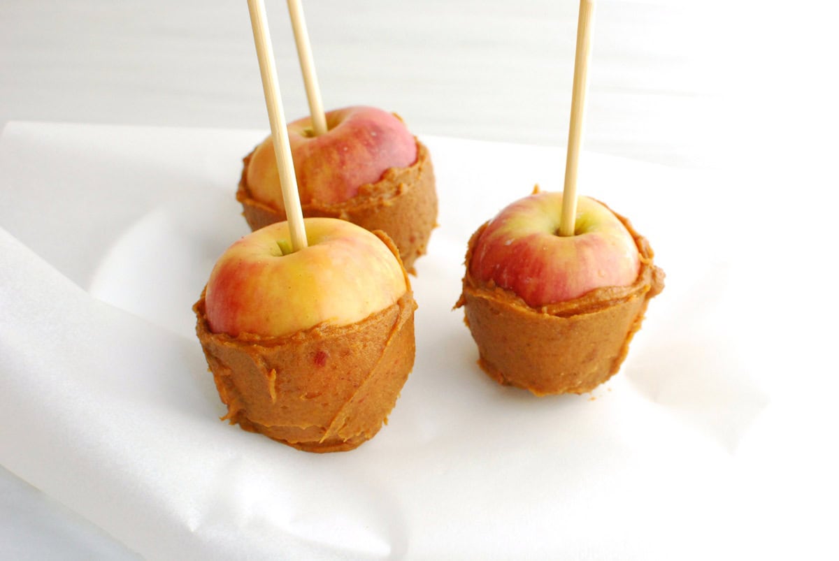 A few apples with the sweetpotato-date caramel spread onto the bottom half of the apple.