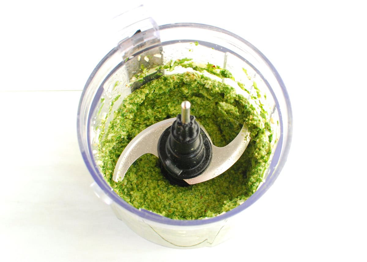 A mini food processor bowl with arugula pesto.