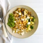 Overhead shot of a quinoa roasted vegetable bowl with arugula pesto.